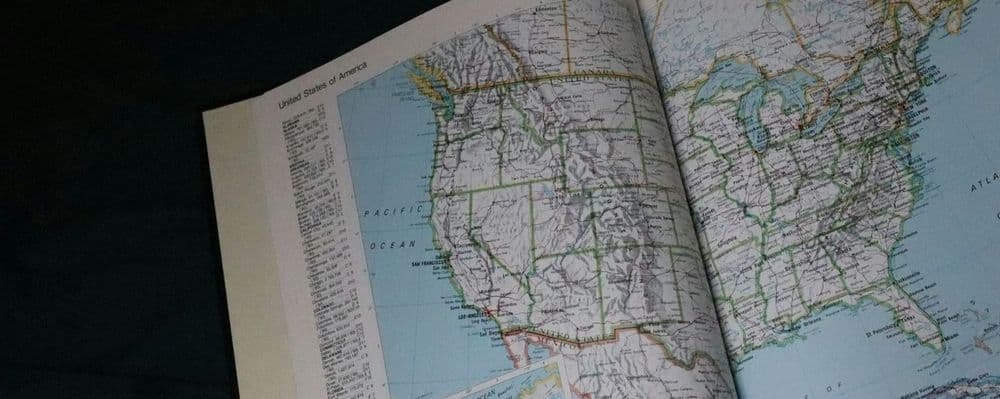 A detailed map of the United States is open in a book, showing state borders.